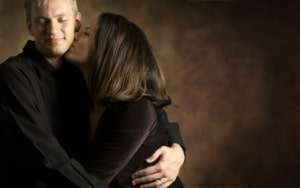 Woman lovingly kissing a man's cheek