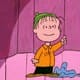 A frame from A Charlie Brown Christmas where Linus drops his blanket and explains the meaning of Christmas while standing on a pink stage.