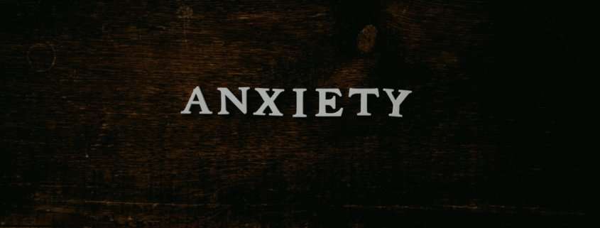 A wood backdrop has the word Anxiety written on it.