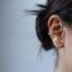 Tinnitus can be maddening. Image of a woman's ear with earrings.