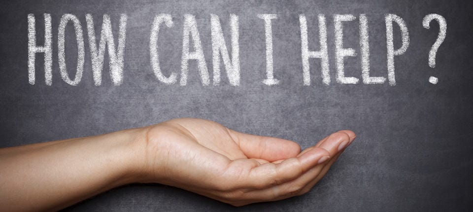 The words, "How can I help?" are written on a chalkboard with an open palm facing up under the words.