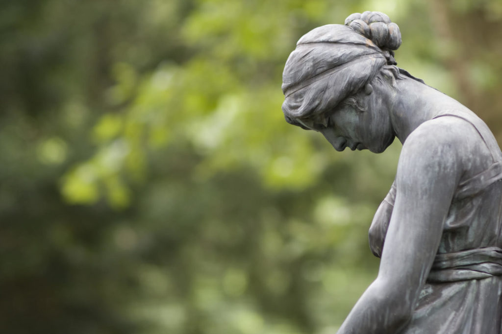 grieving statue at cemetery