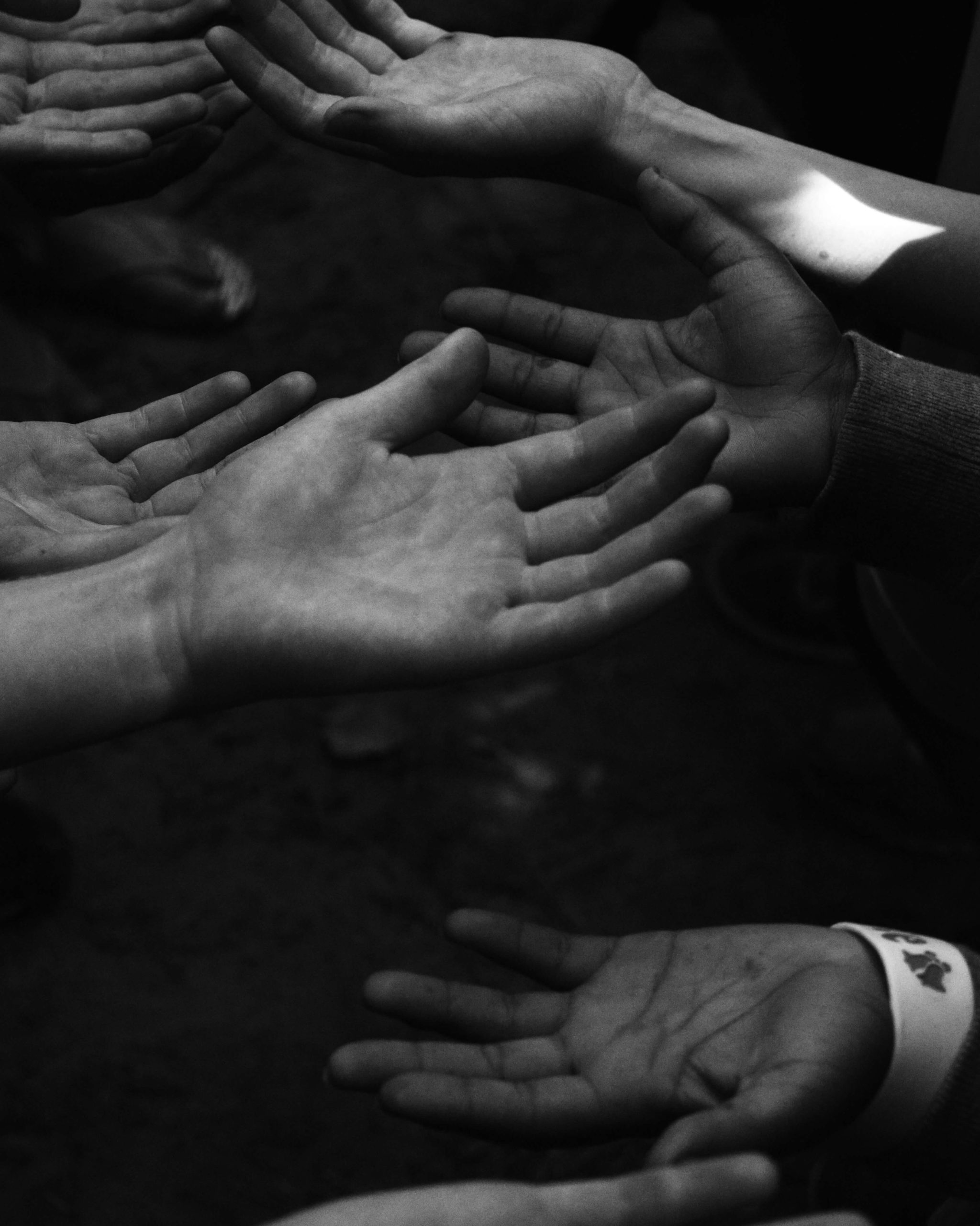 Group of hands reaching out in a supportive gesture, symbolizing healing and care.