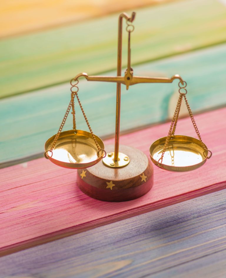 A small set of traditional balance scales on a rainbow table.