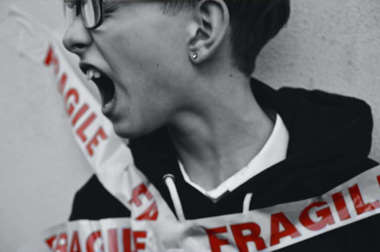 Person expressing stress, with "Fragile" tape, symbolizing a highly sensitive personality.